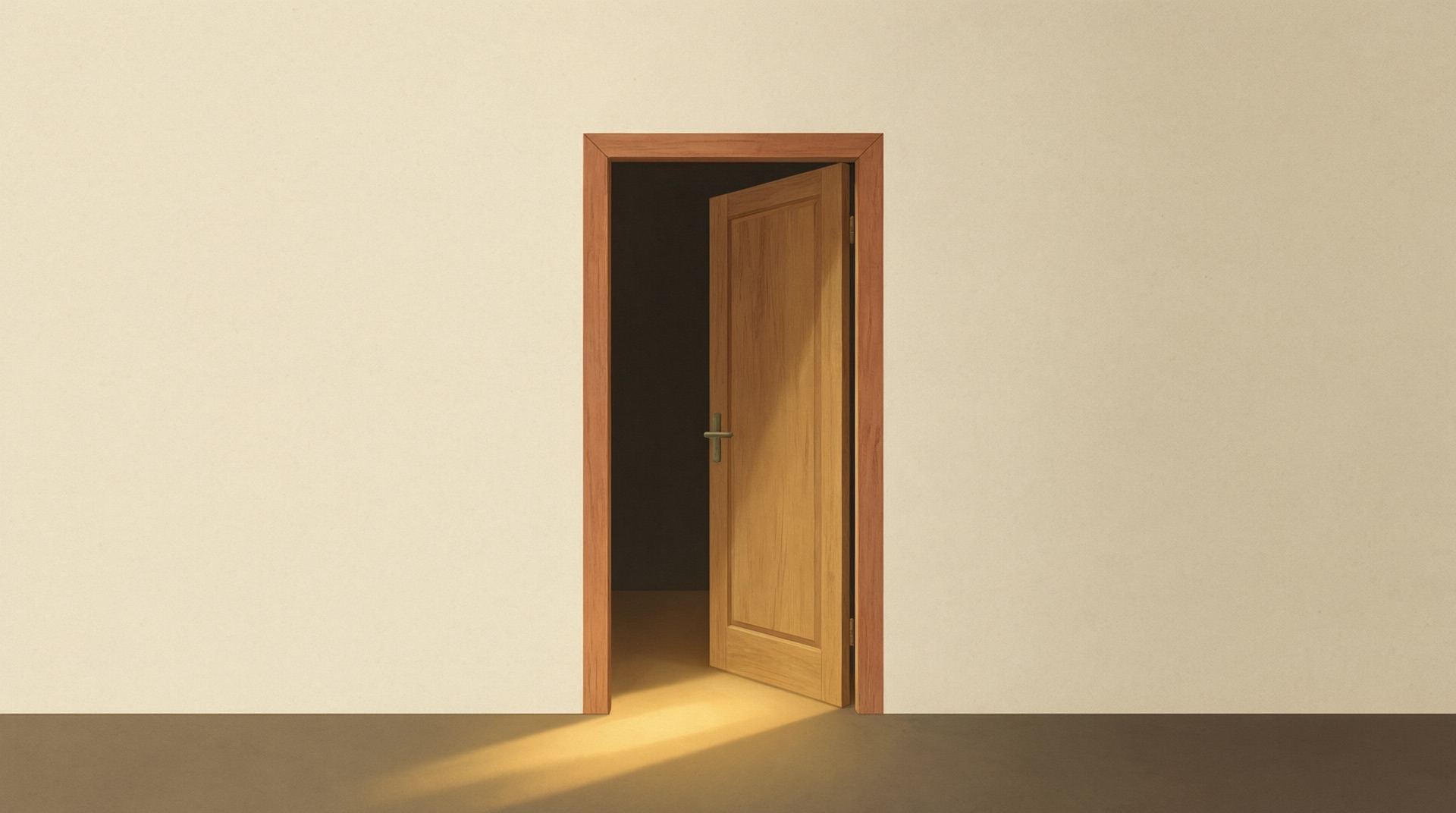 A plain wooden door standing slightly open in a bare cream wall, warm light spilling through onto the floor.